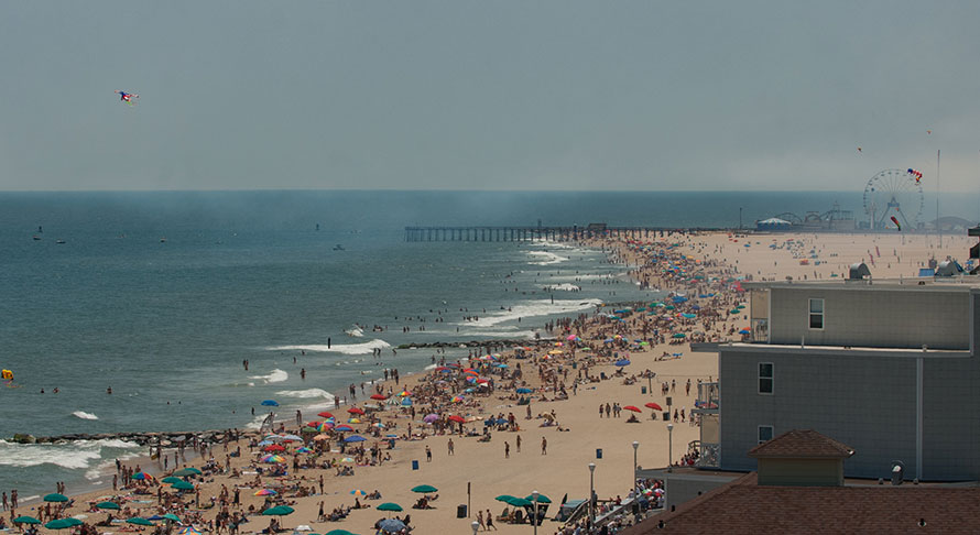 Aeriel view of crowded Ocean City beach, boardwalk, and inlet pier and amusements